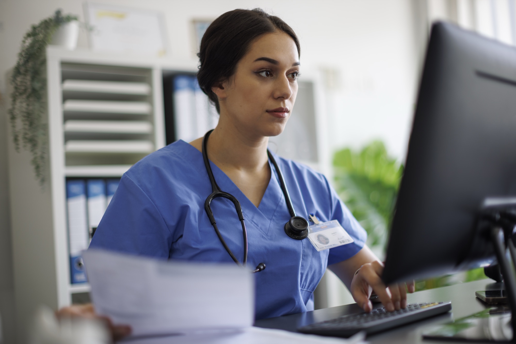 A clinician entering patient information into a desktop EHR system