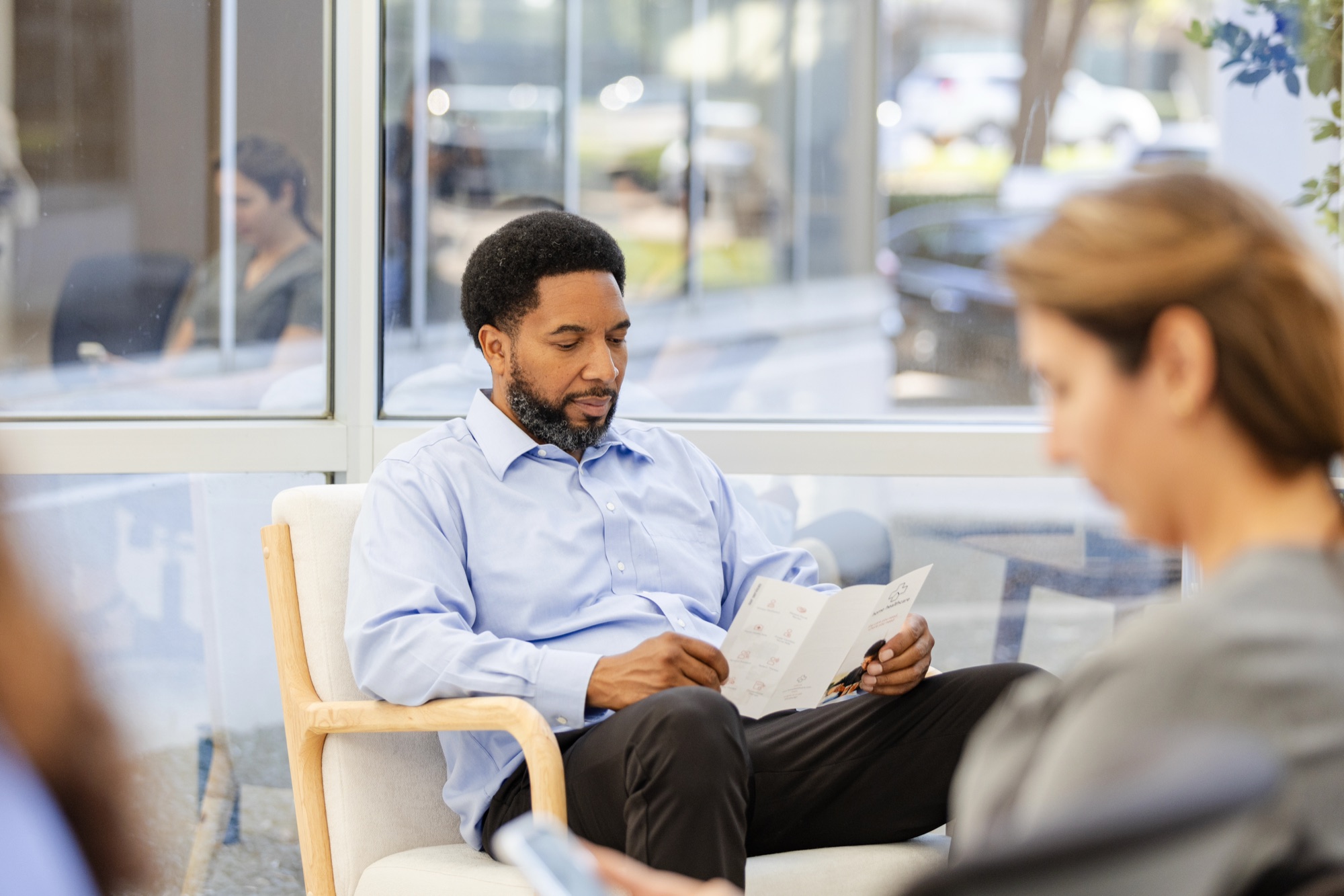 A patient reviewing a health resource pamphlet in a clinic waiting room