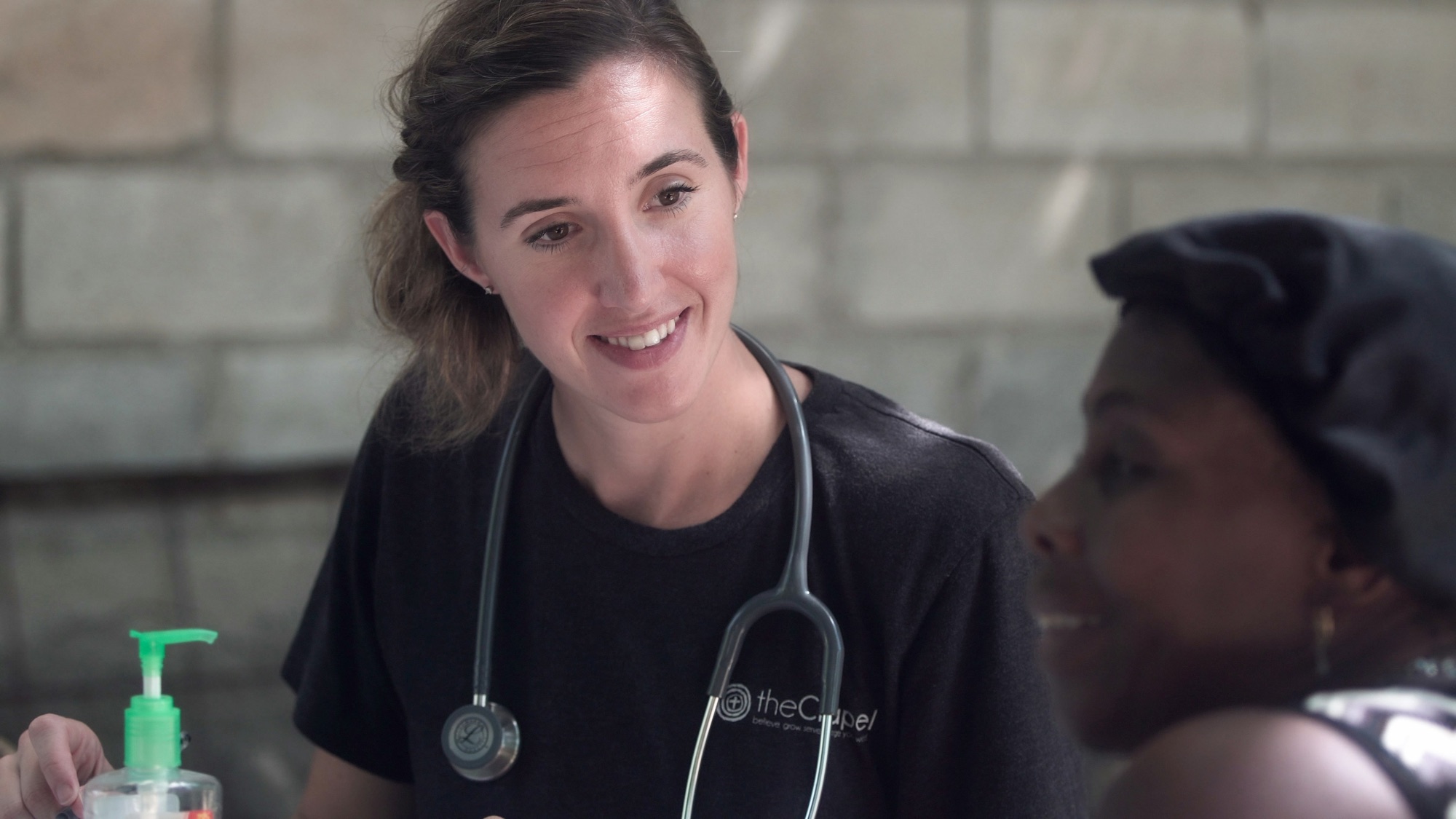 A volunteer medical worker talking with a patient during a community health outreach visit